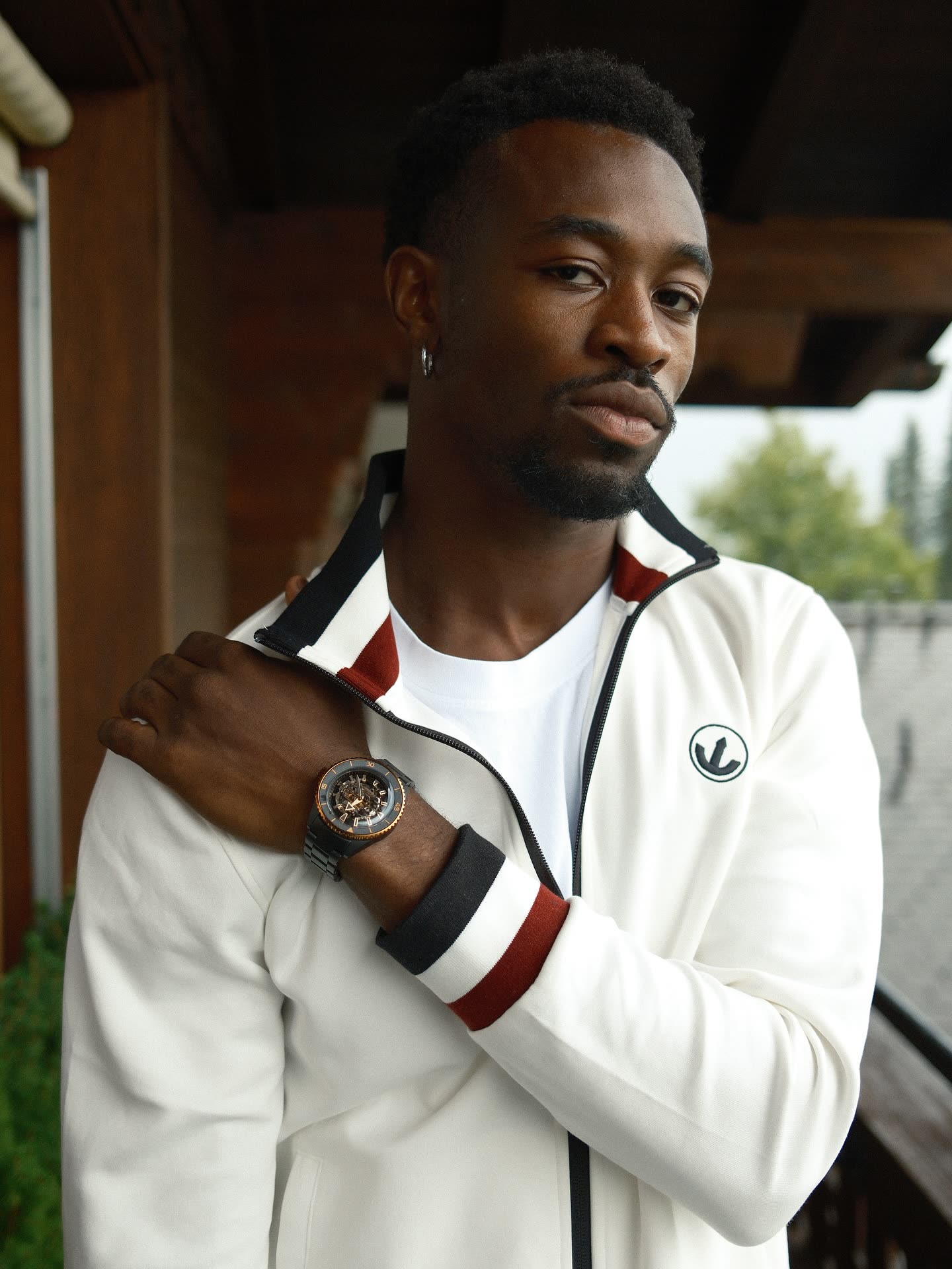 @akamztweenty in a retro track jacket showing a Rado watch