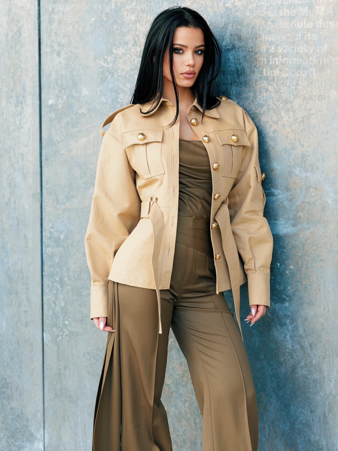 @moarasorio in a beige safari jacket against a concrete wall