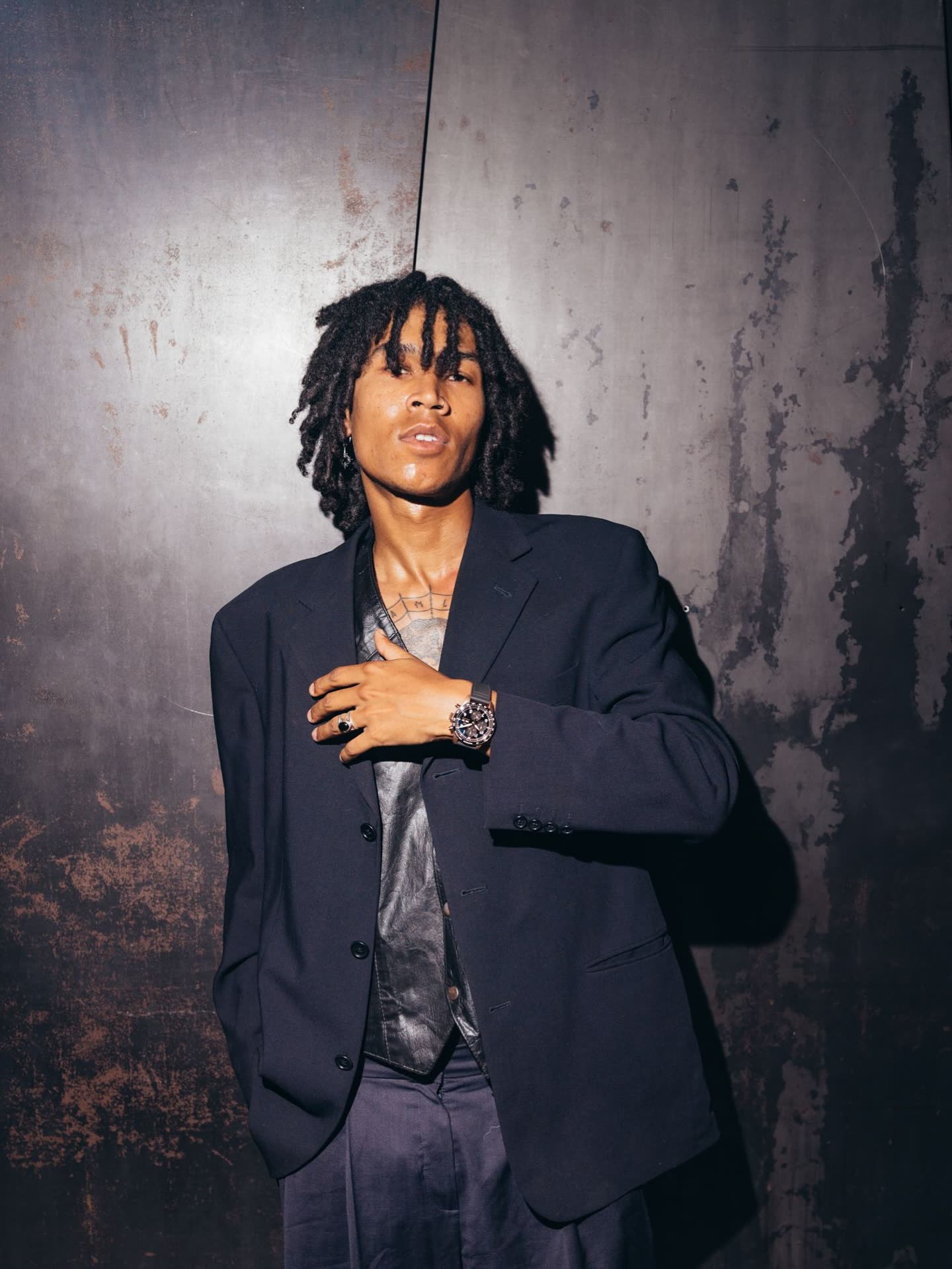 @moonscotty_ in a dark suit wearing an IWC watch